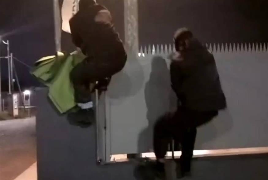 Η στιγμή που μέλη του Ρουβίκωνα πηδούν πάνω από την περίφραξη