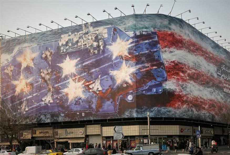 Μια πινακίδα που απεικονίζει ένα κατεστραμμένο αμερικανικό αεροπλανοφόρο και μια επιγραφή που αναγράφει: «Αν σπείρεις τον άνεμο, θα θερίσεις τη θύελλα» (AP Photo/Vahid Salemi)