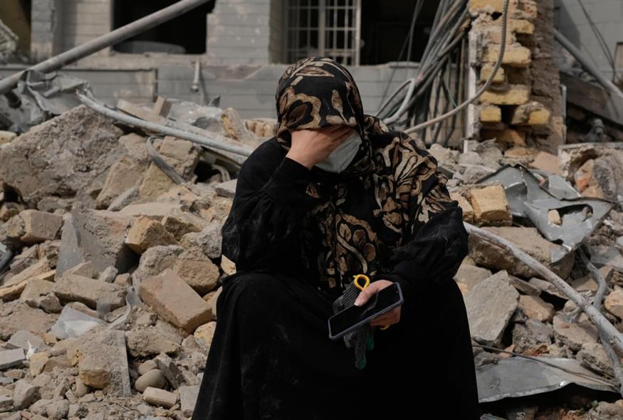 Ιρανή γυναίκα κάθεται στα χαλάσματα μετά από φονικά πλήγματα στην Τεχεράνη (AP)