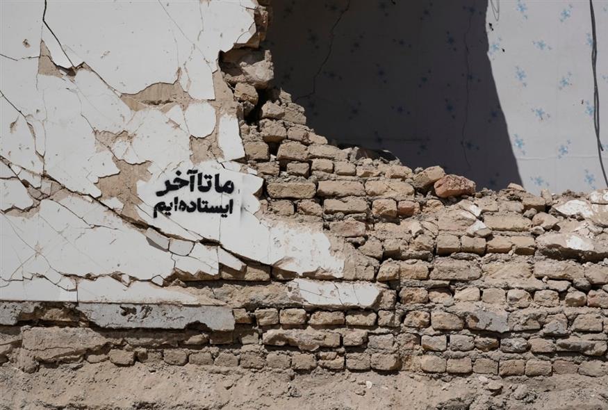 «Θα αντέξουμε ως το τέλος», γραμμένο στα συντρίμμια κτηρίου στην Τεχεράνη (AP Photo/Vahid Salemi)