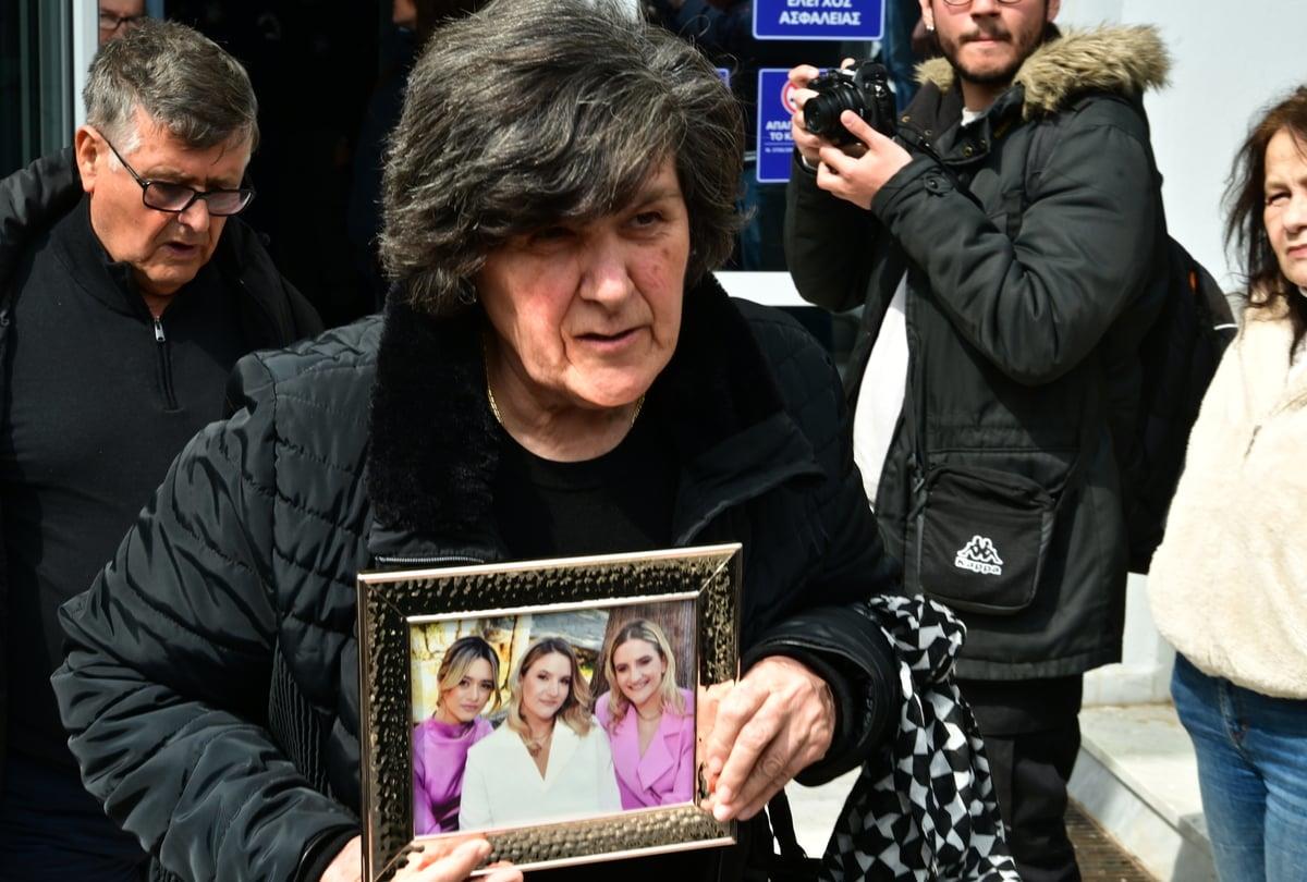 Γυναίκα κρατάει φωτογραφίες έξω.