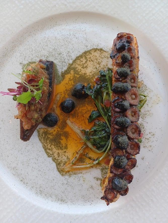 Xταπόδι με άγρια χόρτα, κρεμμύδια ριγανάδα και μαύρο σκόρδο | © Χριστίνα Τσαμουρά