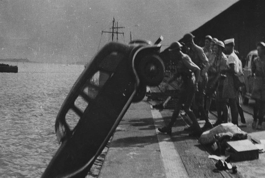 Βρετανοί στρατιώτες πετούν αυτοκίνητο στη θάλασσα για να μην πέσει στα χέρια των Ιαπώνων. /copyright Ap Photos
