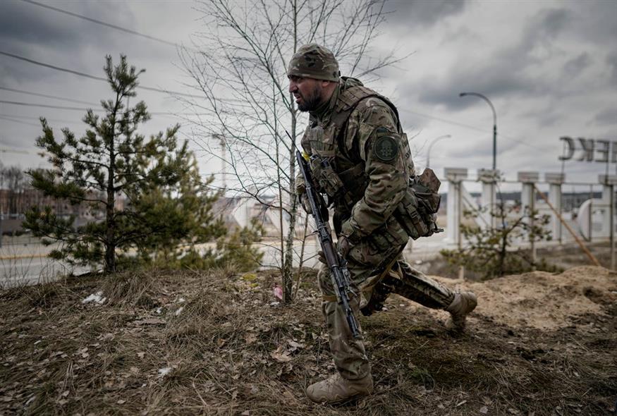 Ένας Ουκρανός στρατιώτης παίρνει θέση βολής καθώς κοιτάζει τα οχήματα που πλησιάζουν στο Irpin / AP Photo/Vadim Ghirda