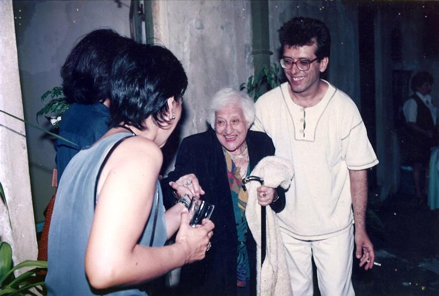 Η Διδώ Σωτηρίου, με πλατύ χαμόγελο, διπλα στον δημοσιογράφο και συγγραφέα Παύλο Κάγιο, χαιρετά τη Μικέλα Χαρτουλάρη