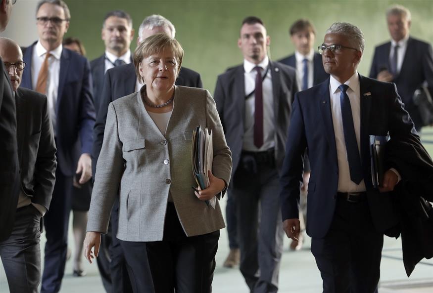 Η Γερμανίδα Καγκελάριος - και η κουστωδία της... (AP Photo/Michael Sohn)