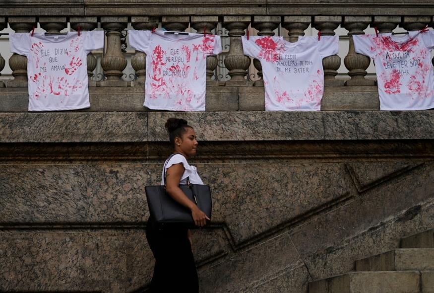 Μπλούζες βαμμένες με κόκκινο μελάνι, ως εναντίωση στις γυναικοκτονίες, κρεμασμένες έξω από το δημοτικό συμβούλιο του Ρίο ντε Τζανέιρο στη Βραζιλία (Silvia Izquierdo/AP)