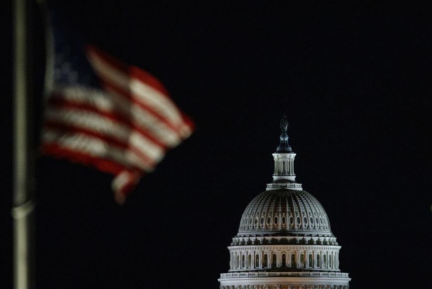 Μια αμερικανική σημαία και η κορυφή από το Αμερικανικό Καπιτώλιο είναι το μέρος στο οποίο συνέρχεται το Κογκρέσο των Ηνωμένων Πολιτειών (AP Photo/Carolyn Kaster)
