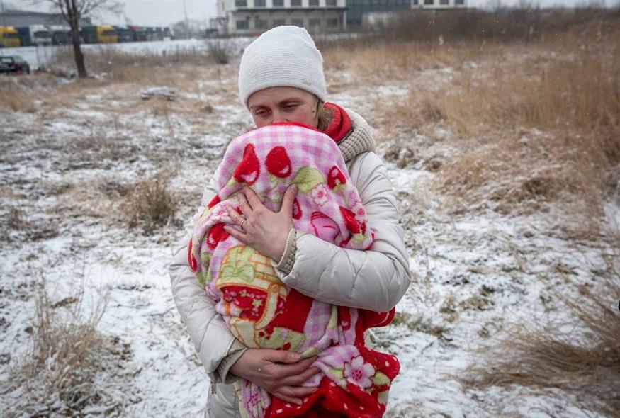 Η Axana Opalenko, 42 ετών, κρατά τον Meron, 2 μηνών, σε μια προσπάθεια να τον ζεστάνει κατά τη φυγή της από την Ουκρανία, στο συνοριακό πέρασμα στο Medyka της Πολωνίας / AP Photo/Visar Kryeziu