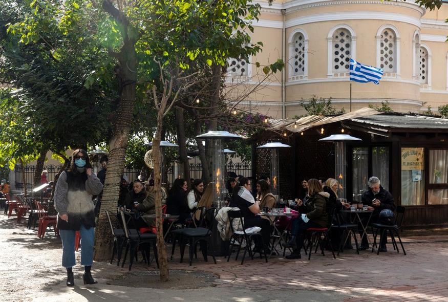 Άνθρωποι κάθονται σε καφετέρια δίπλα σε κεντρικό δρόμο της αγοράς στην Αθήνα / AP Photo/Yorgos Karahalis