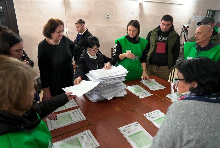 Μέλη εκλογικής επιτροπής καταμετρούν ψηφοδέλτια σε εκλογικό τμήμα της Τιφλίδας (Associated Press)