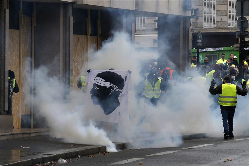 Διαδηλωτής ανάμεσα σε καπνούς από δακρυγόνα  (AP Photo/Michel Euler)