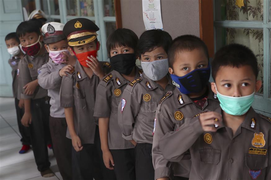 Παιδιά με μάσκες για τον κοροναϊό/(AP Photo/Tatan Syuflana)