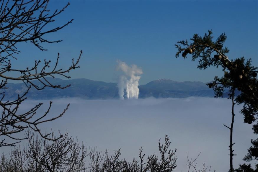 Οι καπνοί από τα φουγάρα του ΑΗΣ Αγίου Δημητρίου ορθώνονται πάνω από τα σύννεφα