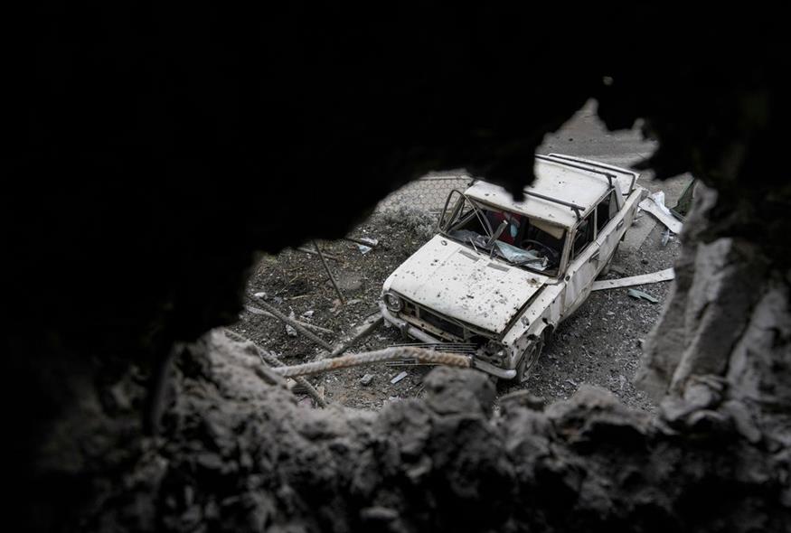 Ένα κατεστραμμένο αυτοκίνητο φαίνεται από μια τρύπα μιας κατεστραμμένης πολυκατοικίας μετά από επίθεση με ρουκέτες στην πόλη Μαριούπολη, Ουκρανία / AP Photo/Evgeniy Maloletka