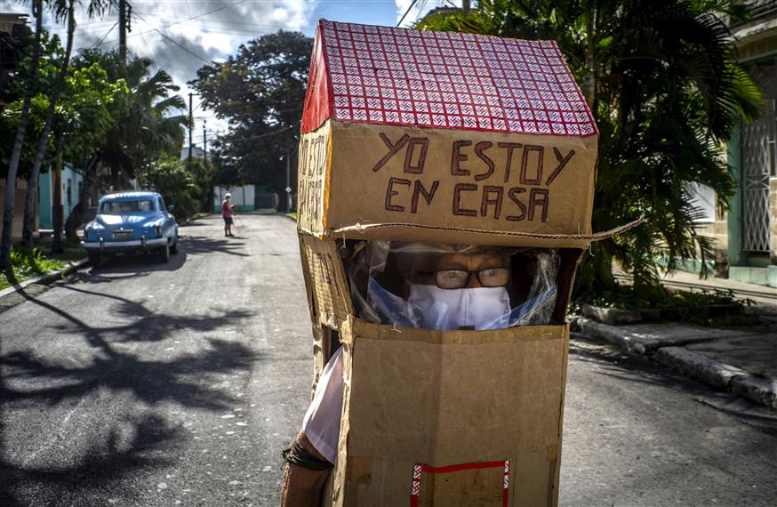 Η 82χρονη Feridia Rojas φορά ένα κινητό «σπίτι» κατασκευασμένο από χαρτόκουτο για να προστατευθεί καθώς χαλαρώνει το lockdown στην Κούβα (copyright: AP Images)
