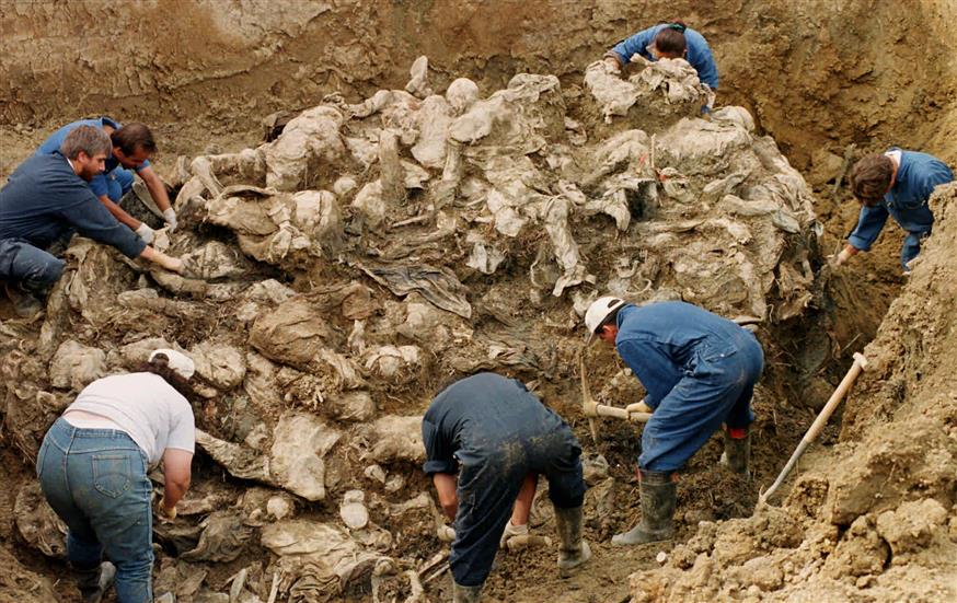 Ερευνητές του Διεθνούς Δικαστηρίου Εγκλημάτων Πολέμου καθαρίζουν το χώμα και τα συντρίμμια ανασύροντας δεκάδες θύματα της Σρεμπρένιτσα, που θάφτηκαν σε μαζικό τάφο κοντά στο χωριό Πίλιτσα/copyright:AP PHOTOS