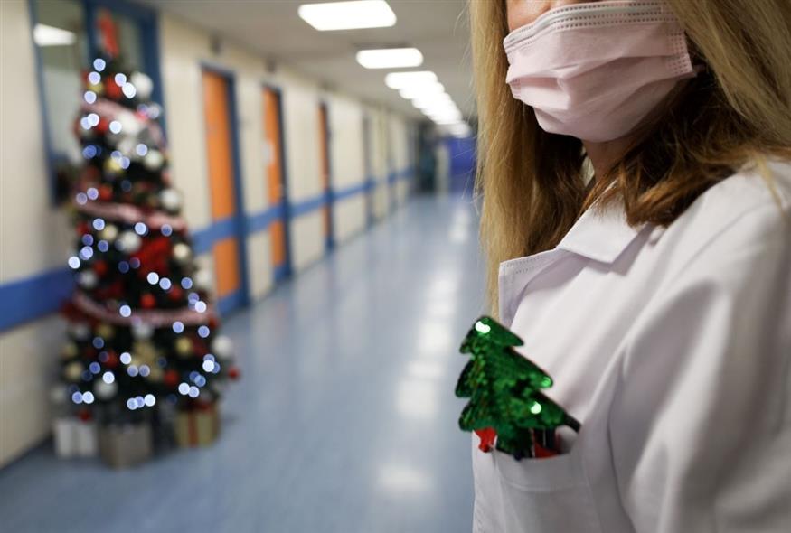 Μια νοσηλεύτρια με τη μάσκα της στο νοσοκομείο, με φόντο ένα χριστουγεννιάτικο δέντρο (ΓΙΑΝΝΗΣ ΠΑΝΑΓΟΠΟΥΛΟΣ/ EUROKINISSI)
