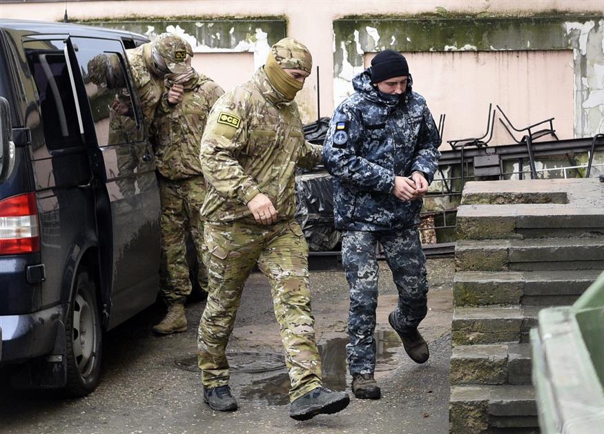 Ένας από τους Ουκρανούς ναυτικούς (δεξιά) οδηγείται στο δικαστήριο, στη Συμφερόπολη της Κριμαίας (AP Photo)