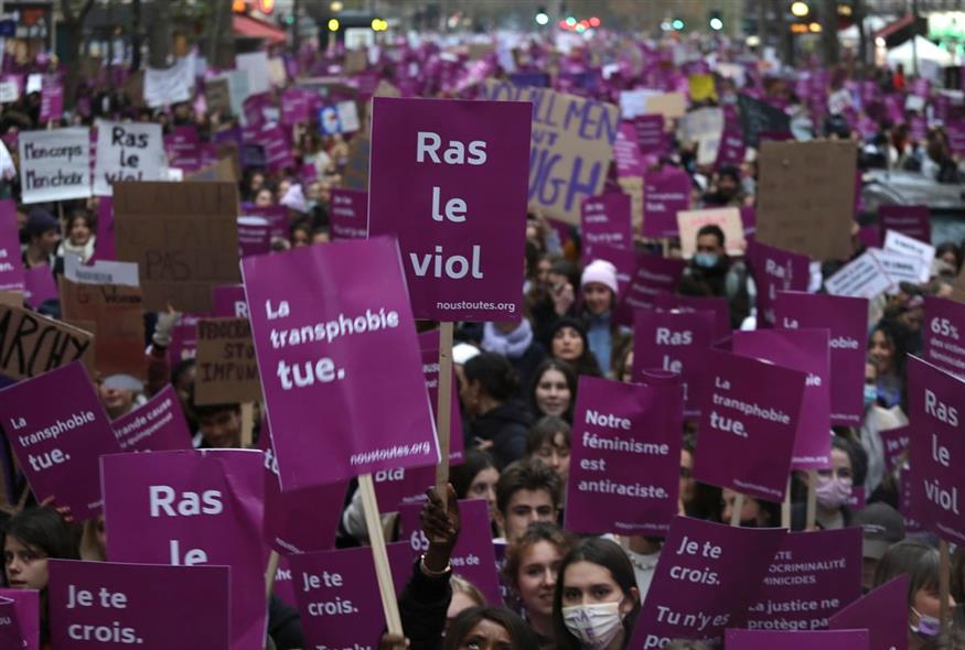 Γυναίκες στο Παρίσι διαδηλώνουν με αφίσες, με μία στο κέντρο να γράφει «αρκετά με τους βιασμούς» (AP Photo/Adrienne Surprenant, File)