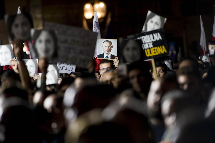 Διαδηλωτές με πλακάτ που απεικονίζουν τη δημοσιογράφο, αλλά και τον Μουσκάτ (AP Photo)