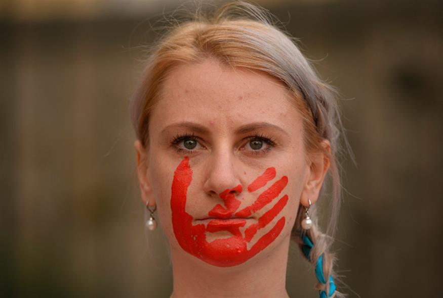 Μια γυναίκα με ένα κόκκινο χέρι ζωγραφισμένο στο πρόσωπό της ως σύμβολο της ρωσικής επιθετικότητας συμμετέχει σε διαμαρτυρία κατά του πολέμου της Ρωσίας στην Ουκρανία / AP Photo/Andreea Alexandru