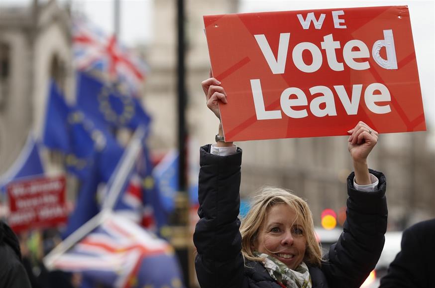 Η κυρία υπενθυμίζει τι ψηφίστηκε στη χώρα της (AP Photo/Alastair Grant)