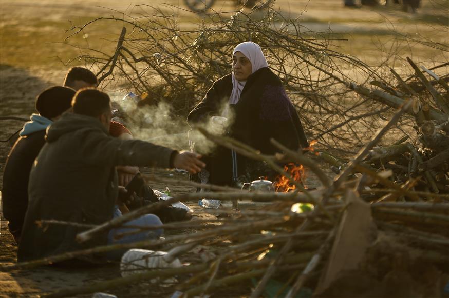Πρόσφυγες και μετανάστες προσπαθούν να ζεσταθούν από το κρύο (AP Photo/Emrah Gurel)