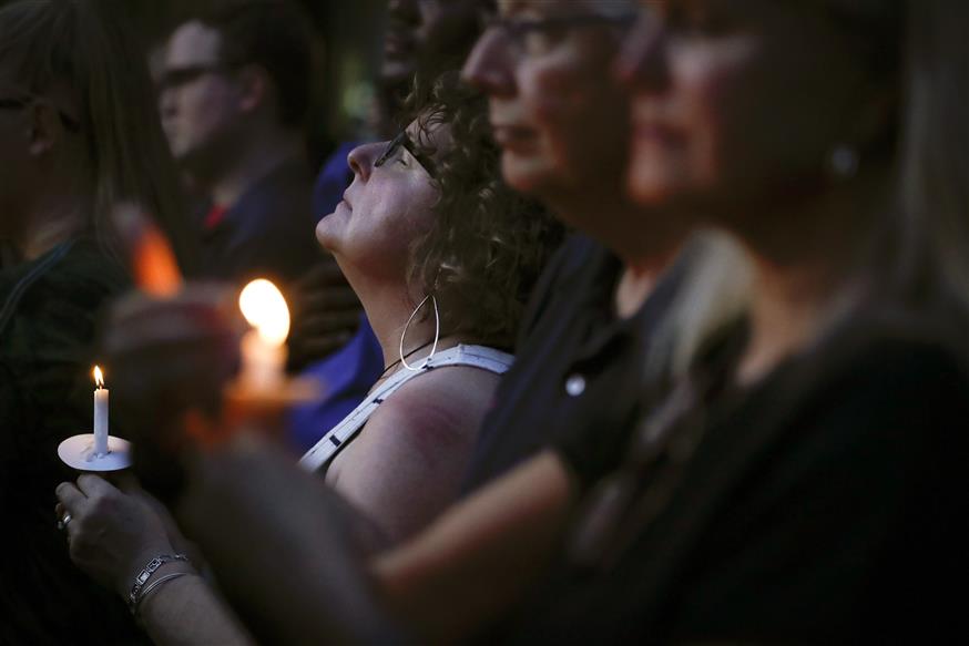 Πολίτες αποτίουν φόρο τιμής στα θύματα του μακελειού στο Ντέιτον (AP Photo/John Minchillo)