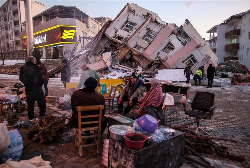 Σεισμόπληκτοι στέκονται μπροστά από τα συντρίμμια στην Τουρκία (AP Photo/Emrah Gurel)
