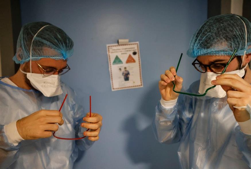 Μέλη του ιατρικού προσωπικού προσαρμόζουν τα προστατευτικά τους γυαλιά στον θάλαμο λοιμωδών νοσημάτων του Πανεπιστημιακού Νοσοκομείου του Στρασβούργου, στην ανατολική Γαλλία / AP Photo/Jean-Francois Badias