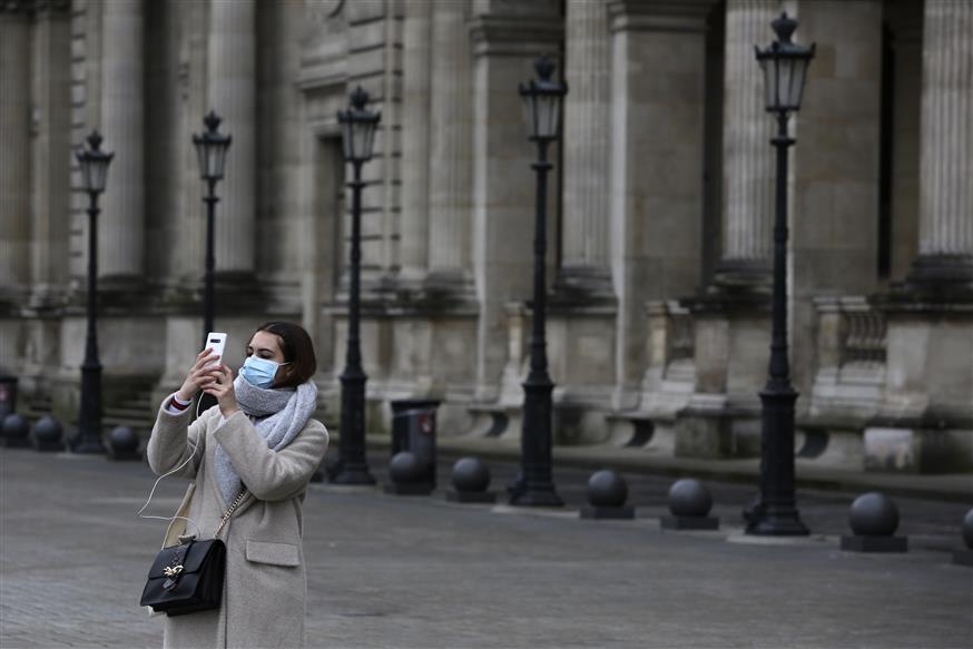 Τουρίστρια με μάσκα έξω από το μουσείο του Λούβρου (AP Photo/Rafael Yaghobzadeh)