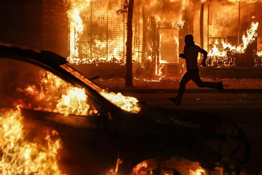 Διαδηλωτής ανάμεσα στις φωτιές στη Μινεάπολη (AP Photo/John Minchillo)