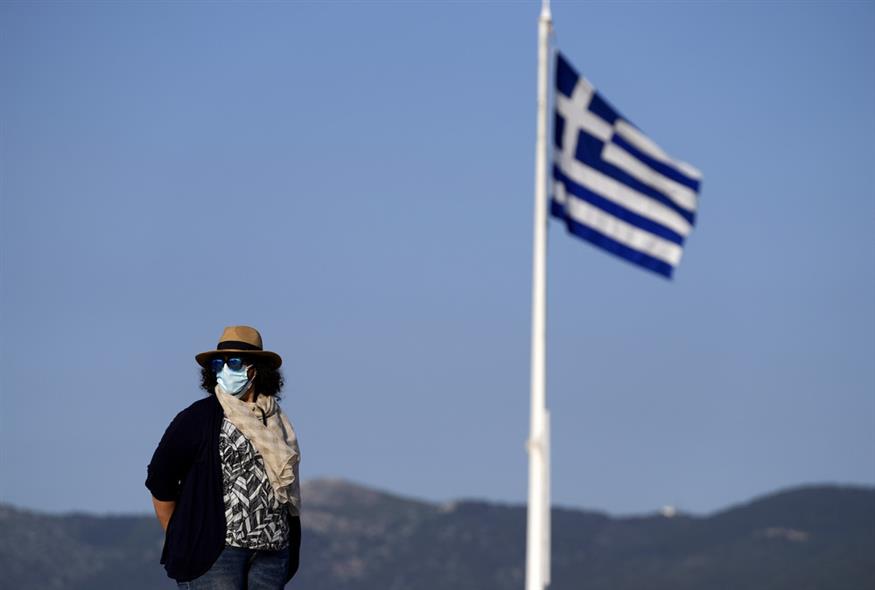 Γυναίκα στο λόφο της Ακρόπολης φορά προστατευτική μάσκα προσώπου / AP Photo/Thanassis Stavrakis