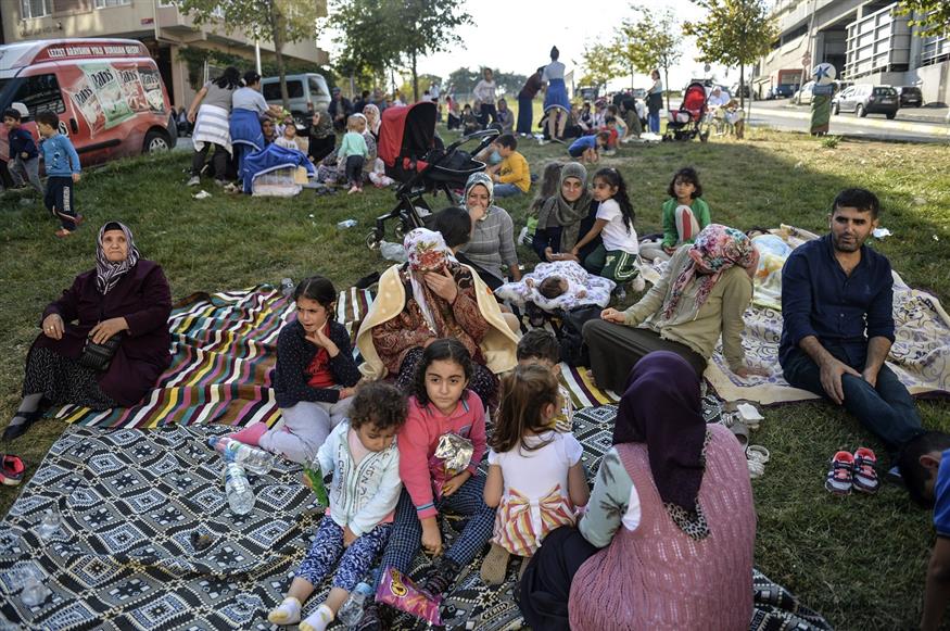 Ανάστατοι οι πολίτες κάθονται σε ανοικτούς χώρους (Ibrahim Mase/DHA via AP)