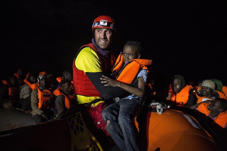 Ένας άνδρας της ισπανικής μη κυβερνητικής οργάνωσης Proactiva Open Arms βοηθά στην αποβίβαση ένα προσφυγόπουλο (AP Photo/Olmo Calvo)