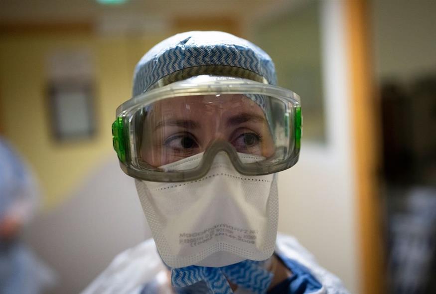 Νοσοκόμα έτοιμη για να μπει στο δωμάτιο ενός ασθενούς με COVID-19 / AP