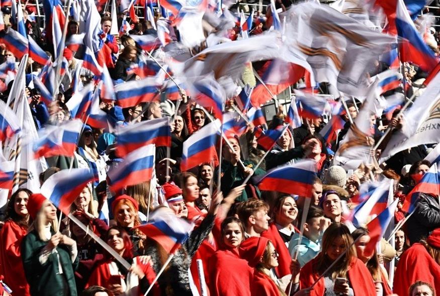Το πλήθος στο στάδιο Λουζνίκι της Μόσχας, κουνάει ρωσικές σημαίες υπέρ του πολέμου στην Ουκρανία (Associated Press)