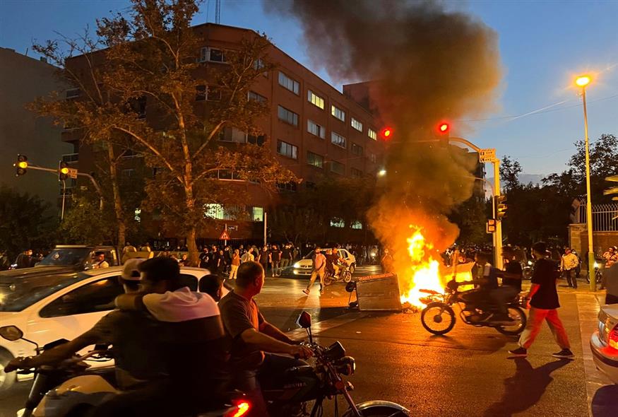 Mια μοτοσικλέτα της αστυνομίας και ένας κάδος απορριμμάτων καίγονται κατά τη διάρκεια διαμαρτυρίας για το θάνατο της Mahsa Amini / AP Photo