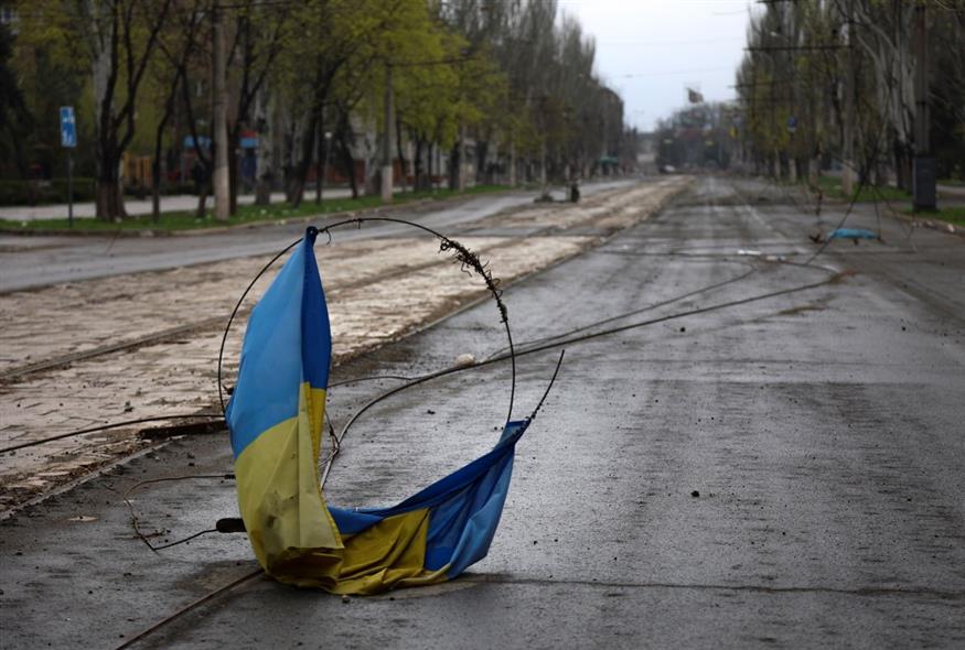 Ουκρανική σημαία μέσα στις καταστροφές του πολέμου (AP Photo/Alexei Alexandrov)