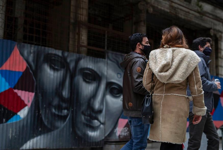 Πολίτες με μάσκες στην πόλη/AP Photo/Petros Giannakouris