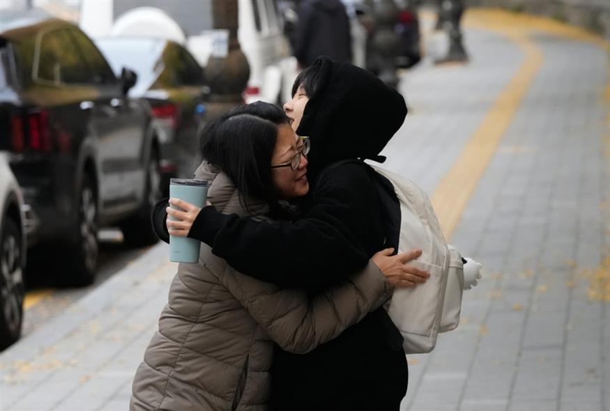 Μαθήτρια στη Σεούλ αγκαλιάζει τη μητέρα της προτού εισέλθει στο Λύκειό της για τις εξετάσεις (Ahn Young-joon/AP)