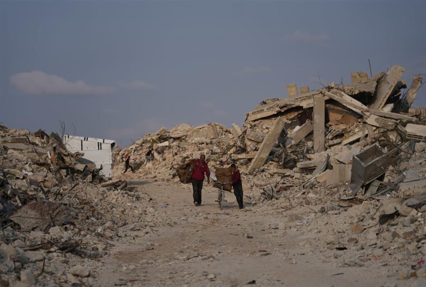 Παλαιστίνιοι περπατούν στα ερείπια της Γάζας (Jehad Alshrafi/AP)