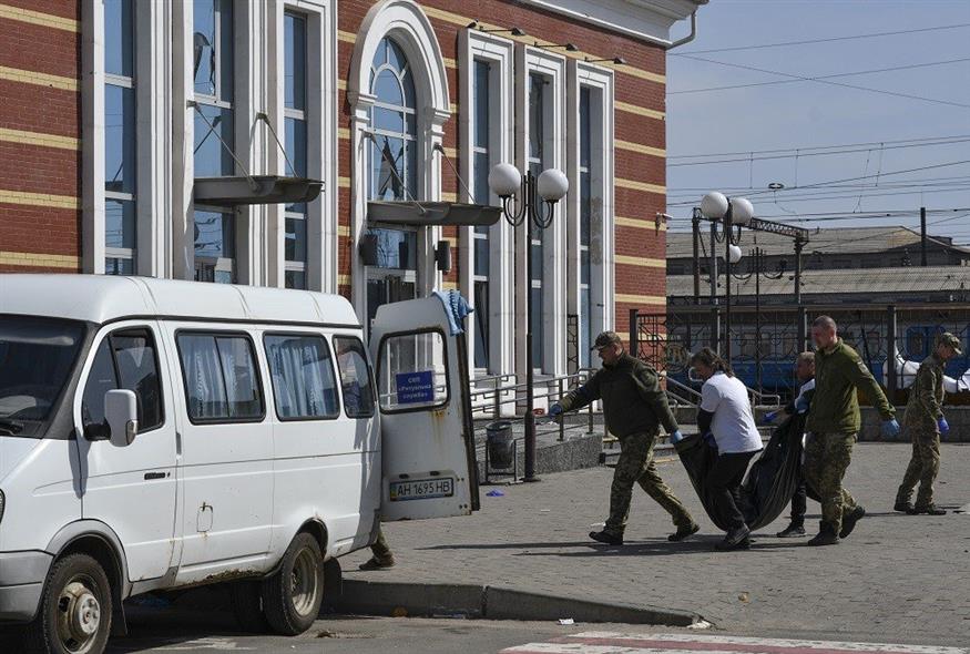 Ουκρανοί στρατιώτες μεταφέρουν πτώματα από τον ρωσικό βομβαρδισμό στο σιδηροδρομικό σταθμό του Κραματόρσκ (Associated Press)
