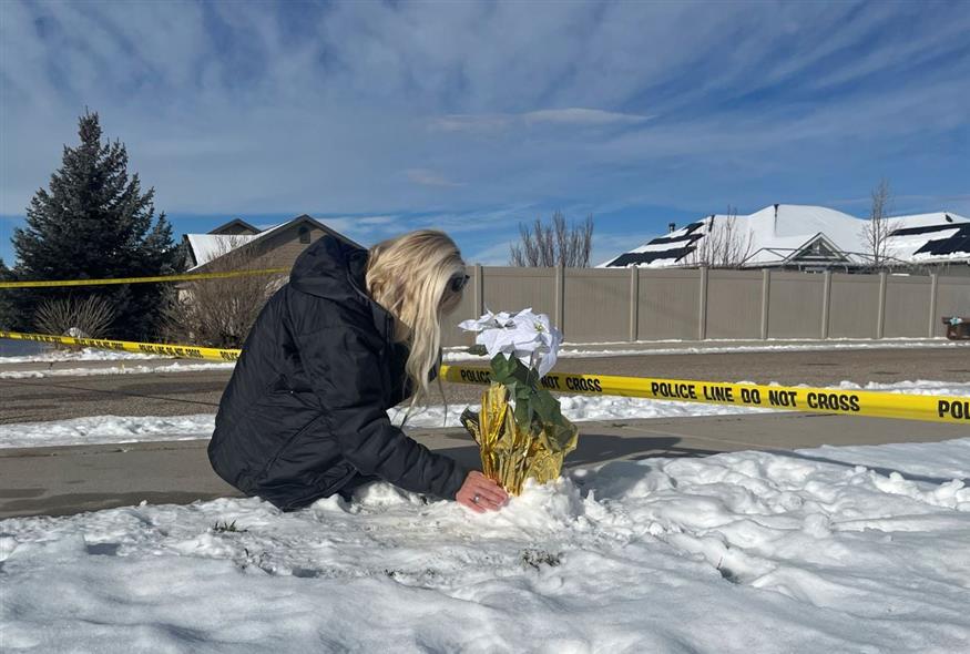 Μια γυναίκα αφήνει λουλούδια έξω από το σπίτι που σημειώθηκε η τραγωδία (AP Photo/Sam Metz)