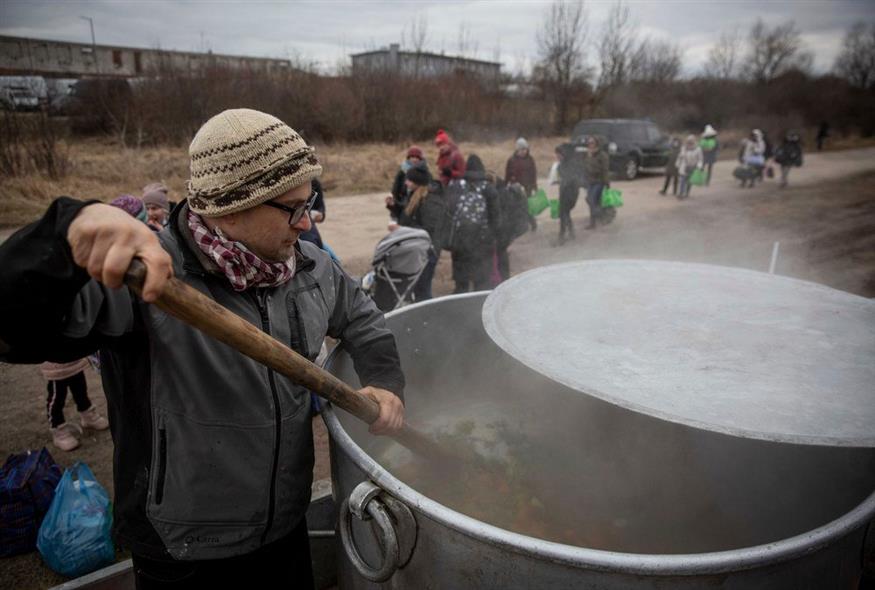Ο Τσέχος εθελοντής Lukas Saranga μαγειρεύει σούπα σε μια τεράστια κατσαρόλα για τους πρόσφυγες που εγκαταλείπουν την Ουκρανία / AP Photo/Visar Kryeziu