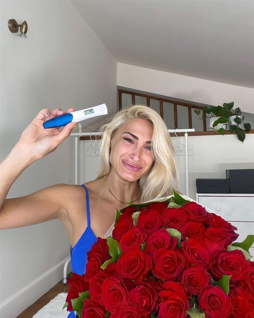 Η Ιωάννα Τούνη κρατάει μία ανθοδέσμη με πολλά κόκκινα τριαντάφυλλα καθώς και το θετικό τεστ εγκυμοσύνης (Copyright: Instagram)