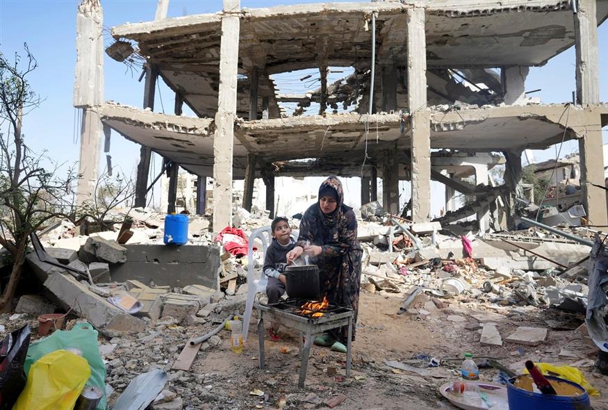 Γάζα: Μια μητέρα μαγειρεύει μπροστά στο γκρεμισμένο από τους βομβαρδισμούς σπίτι της οικογένειας   (AP Photo/Adel Hana)