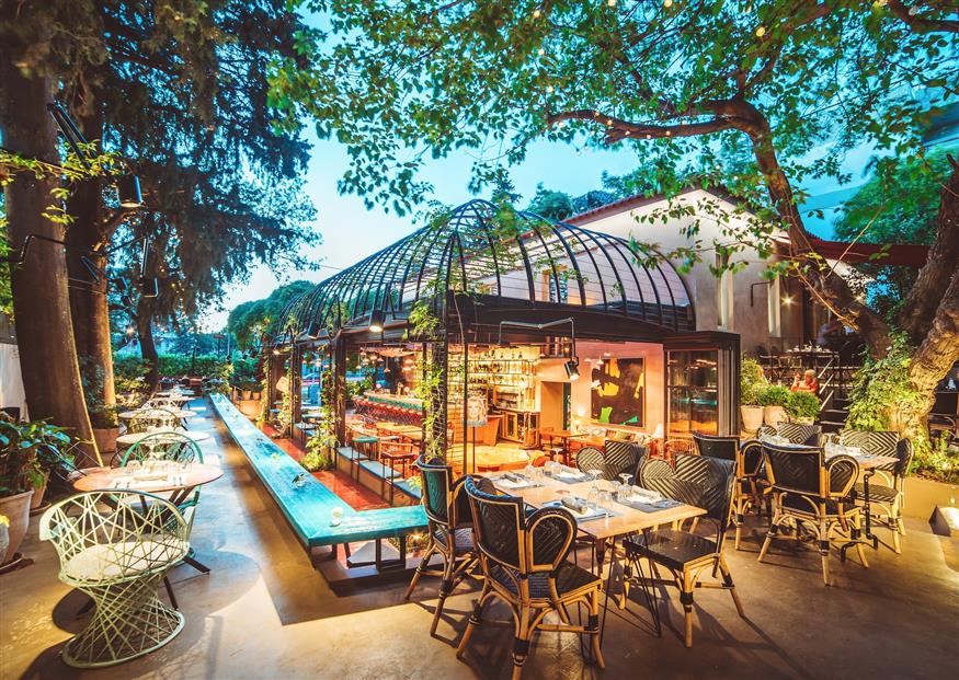 Tα τραπέζια απλώνονται γύρω από το glass house του Artisanal Lounge & Gardens