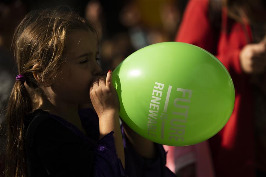 A child inflates a balloon that reads: "Future is Renewable"/(AP Photo/Francisco Seco)